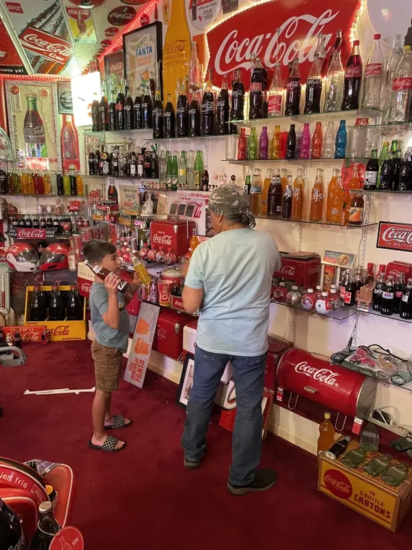 A wall of Coca-Cola bottles from different eras and countries