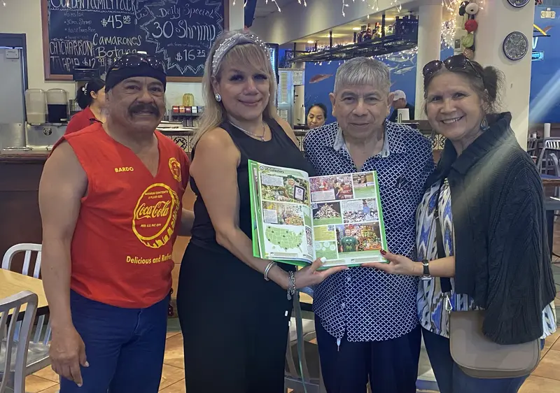 Bardo and Olga Cuellar showing their page in Guinness World Records 2027 with their friend Alfonso