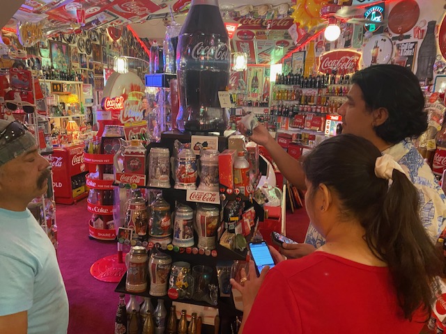 Family admiring the Coca-Cola collection